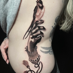 Bird Sitting On Hand Tattoo Womans Ribs